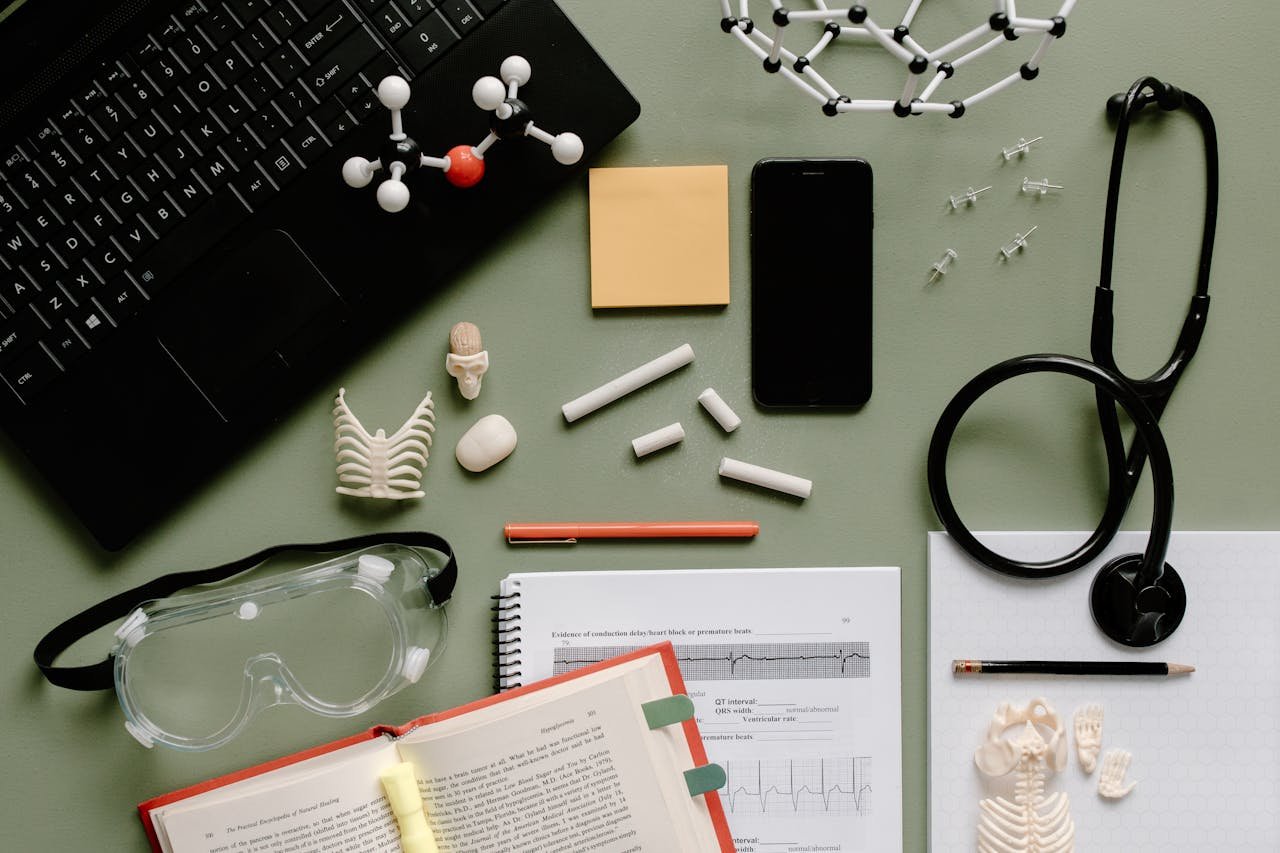 Flat lay of medical tools, journal, and study materials in a lab setting.